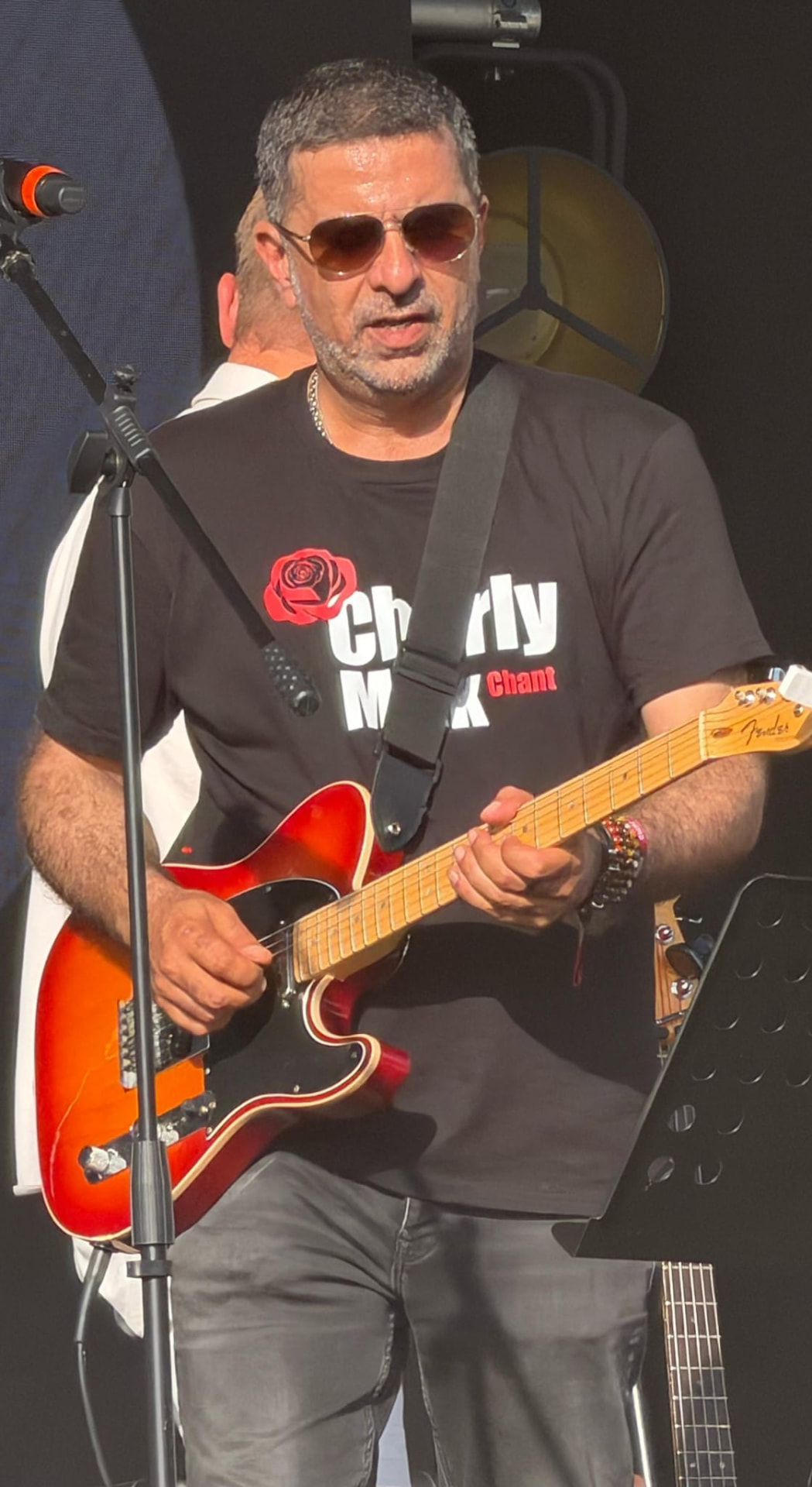 Charly Malk à la guitare lors d'un concert en plein jour