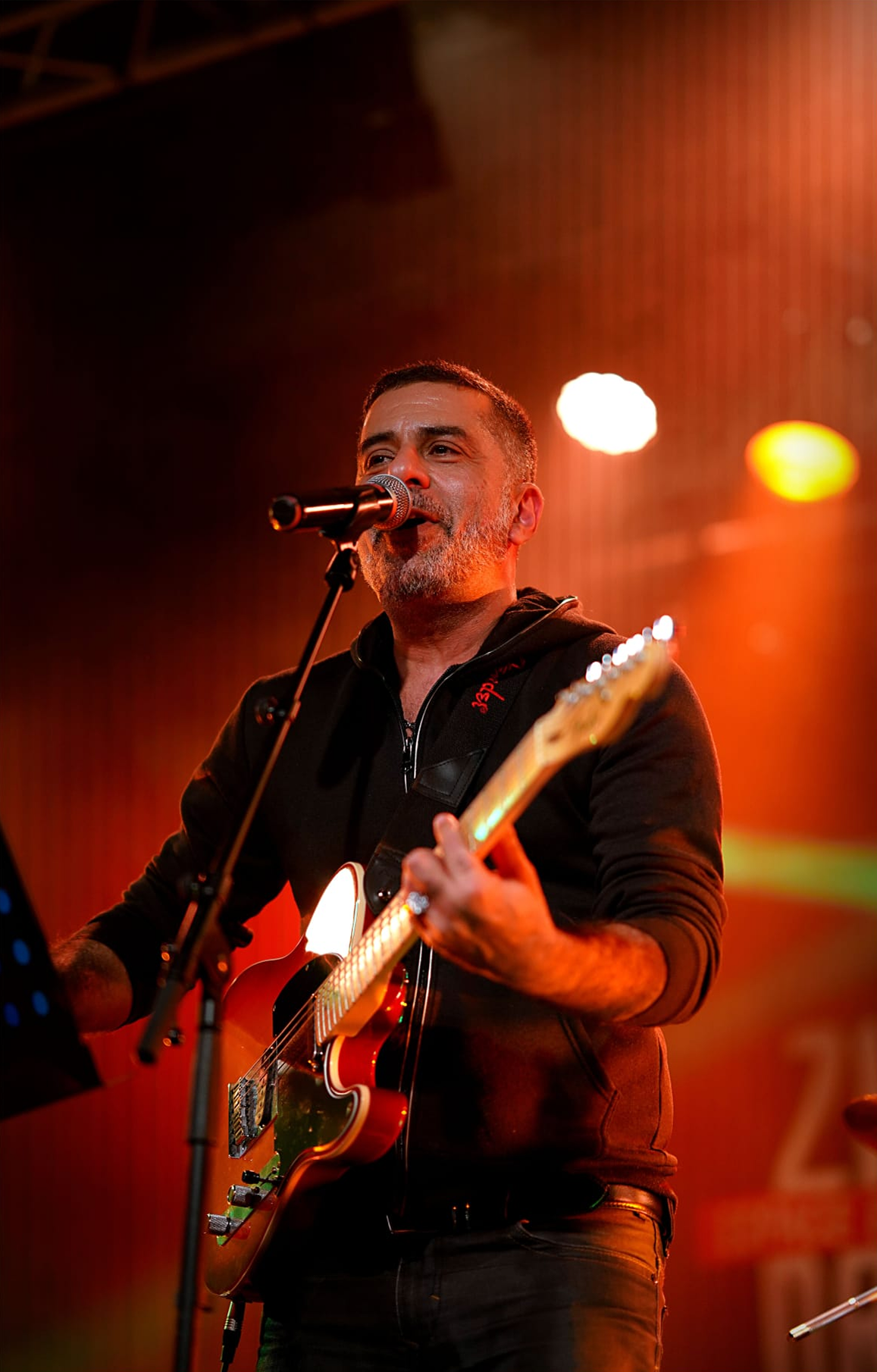 Charly Malk au chant et à la guitare sous les projecteurs
