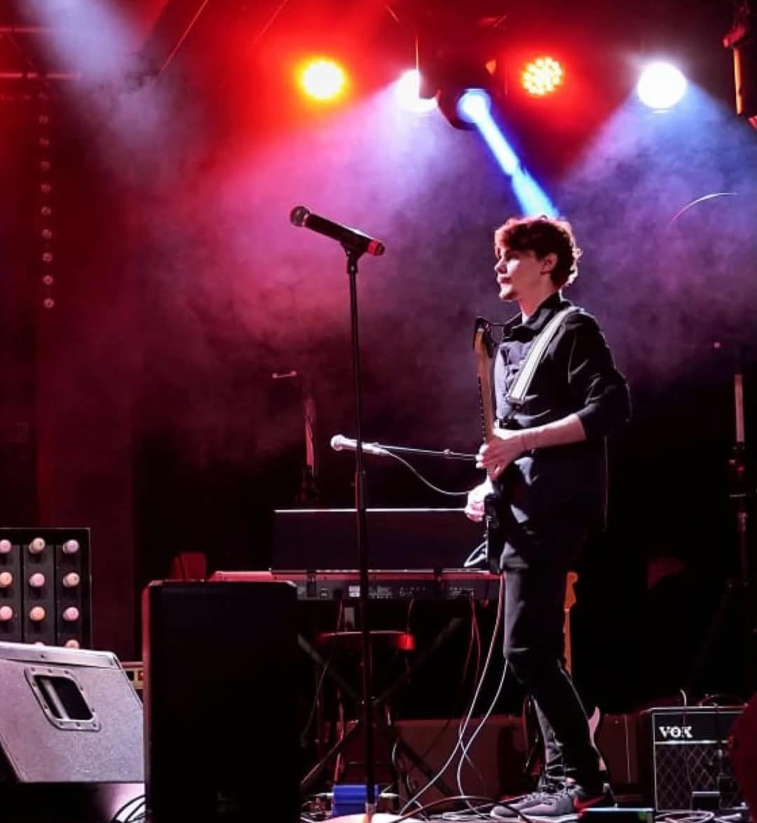 Guitariste sous les projecteurs rouges et bleus